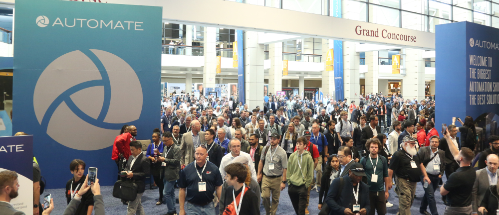 Wide shot of the Automate Show entrance, filled with a large crowd of professionals wearing show badges.