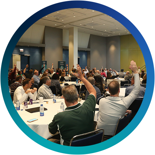 Educator Day attendees with hands raised