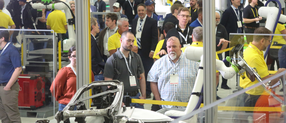 Attendees viewing a robotic arm at the Automate show