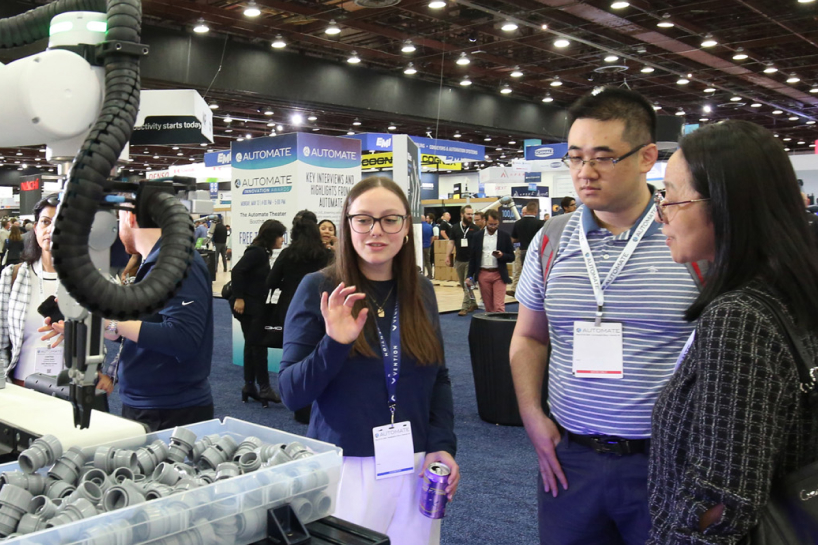 A woman explains to two other people an automation solution.